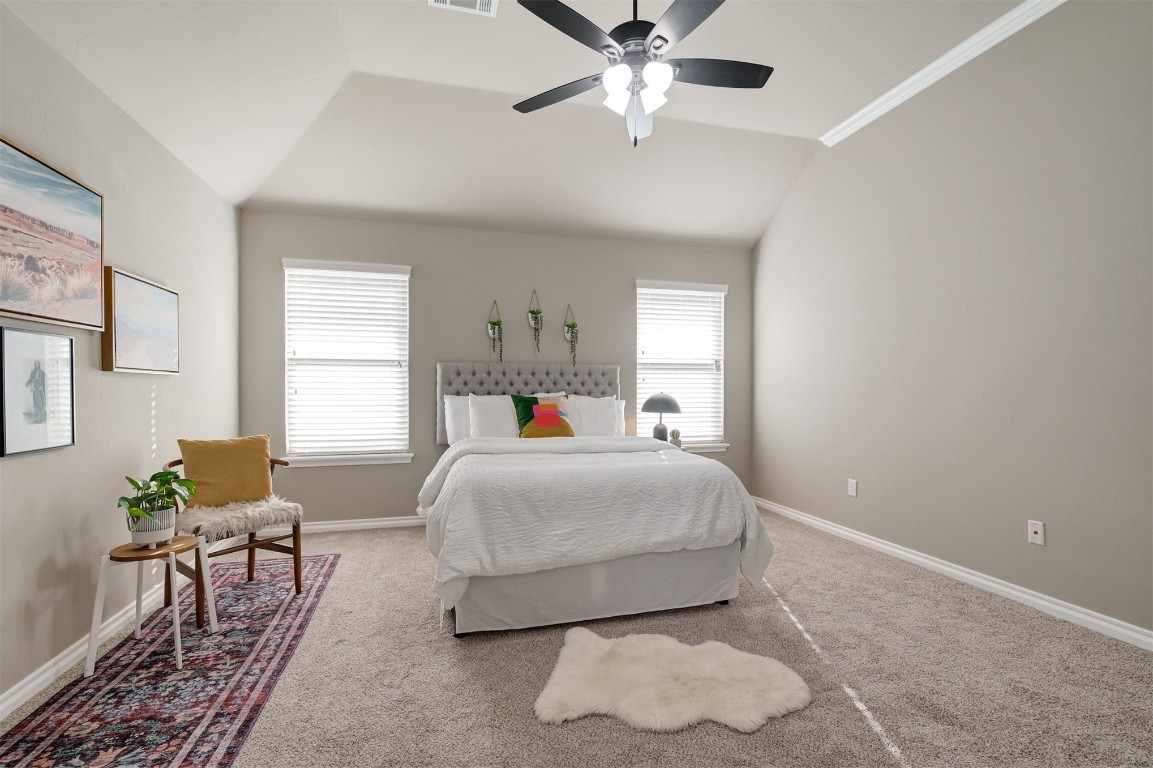 16304 Iron Ridge Road, Edmond, OK 73013 bedroom with carpet flooring, ceiling fan, and lofted ceiling