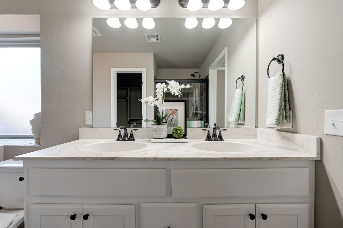 16304 Iron Ridge Road, Edmond, OK 73013 bathroom featuring oversized vanity and double sink