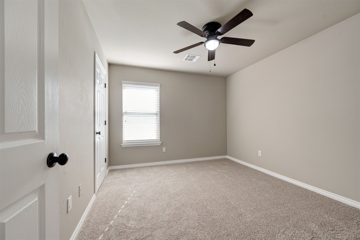 16304 Iron Ridge Road, Edmond, OK 73013 unfurnished room featuring ceiling fan and light carpet