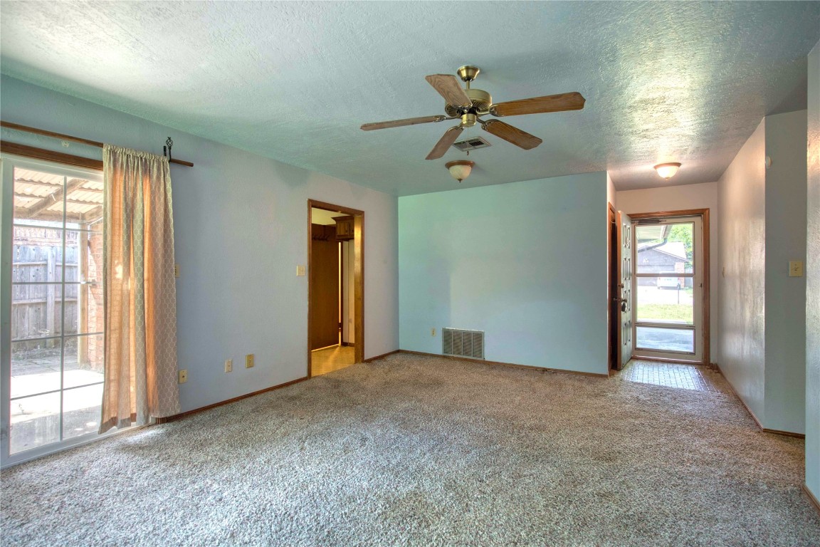 213 Falcon Court, Norman, OK 73069 carpeted empty room with ceiling fan and a textured ceiling