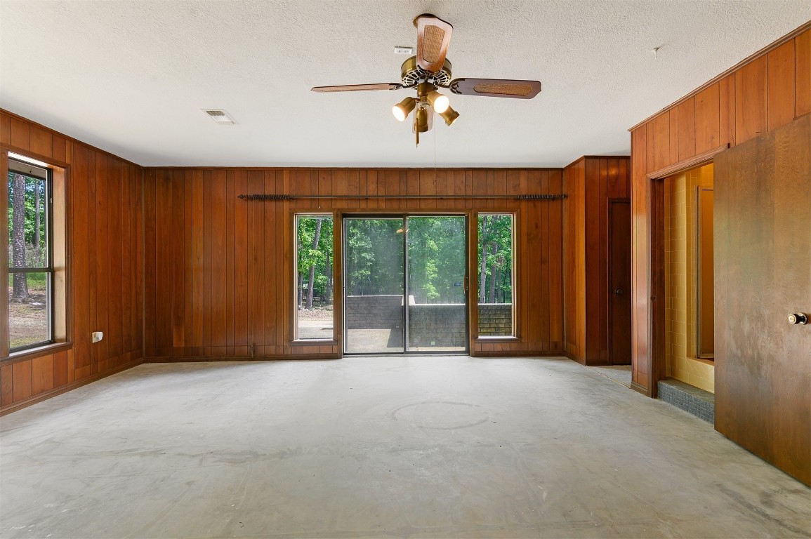 688 Old Hochatown Road, Broken Bow, OK 74728 unfurnished room with a textured ceiling, wood walls, and ceiling fan