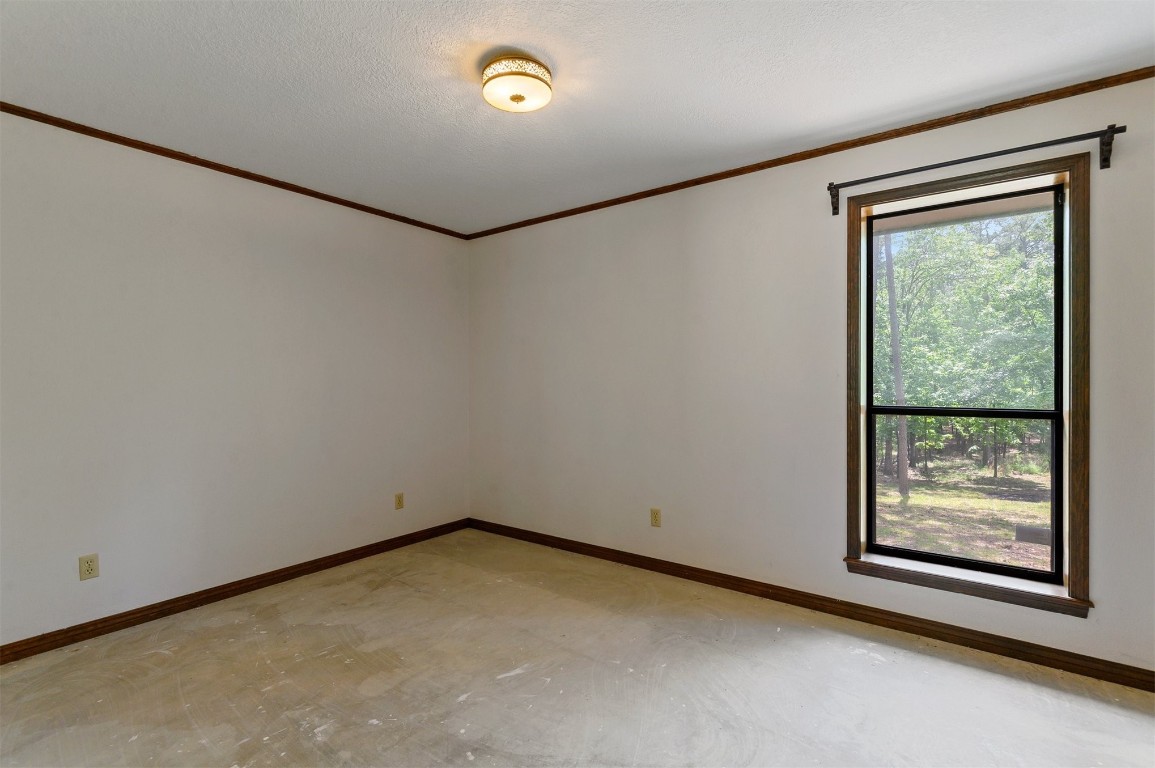 688 Old Hochatown Road, Broken Bow, OK 74728 empty room featuring a textured ceiling and crown molding
