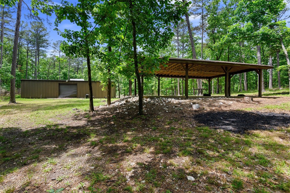 688 Old Hochatown Road, Broken Bow, OK 74728 view of yard featuring a carport, an outdoor structure, and a garage