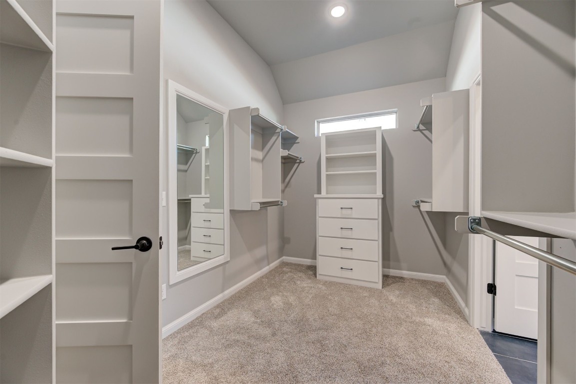 5712 Goldstone Court, Mustang, OK 73064 walk in closet featuring light colored carpet and vaulted ceiling
