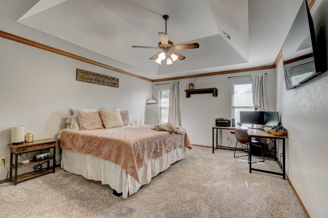 4005 Scissortail Drive, Yukon, OK 73099 bedroom featuring ceiling fan, a raised ceiling, and carpet floors
