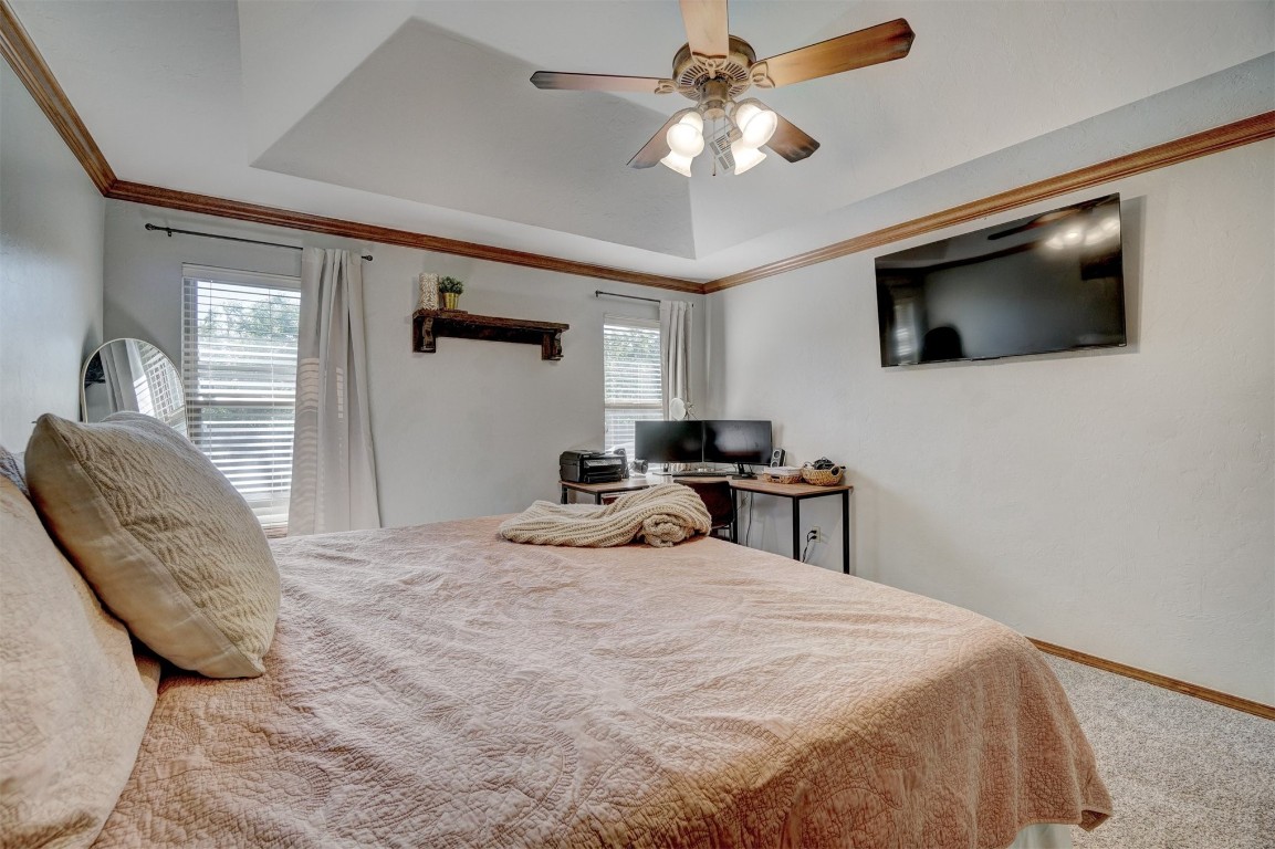 4005 Scissortail Drive, Yukon, OK 73099 bedroom with a raised ceiling, ceiling fan, carpet floors, and multiple windows