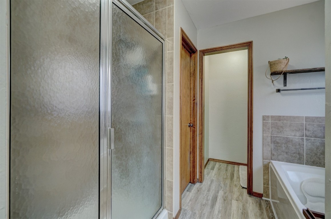 4005 Scissortail Drive, Yukon, OK 73099 bathroom featuring hardwood / wood-style floors and separate shower and tub