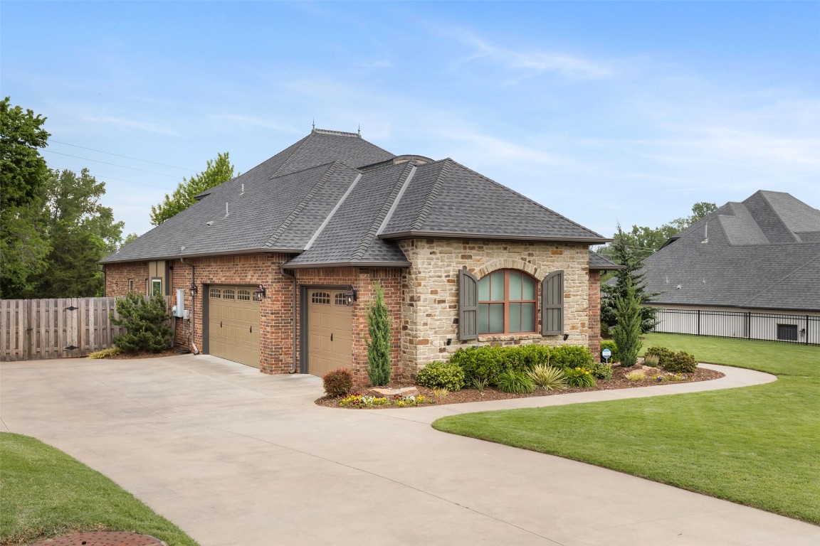 3501 Dornoch Drive, Edmond, OK 73034 french country home featuring a garage and a front lawn