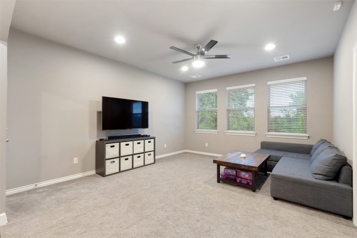 3501 Dornoch Drive, Edmond, OK 73034 living room with light colored carpet and ceiling fan