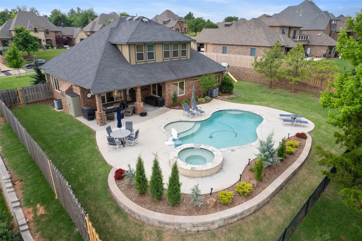 3501 Dornoch Drive, Edmond, OK 73034 view of pool featuring a patio area, a lawn, and an in ground hot tub