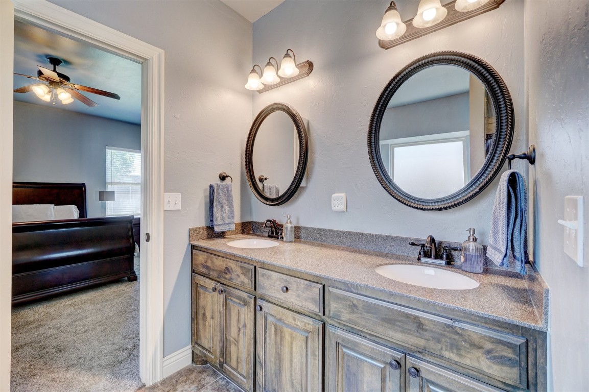 16009 Petaluma Place, Edmond, OK 73013 bathroom featuring dual sinks, oversized vanity, and ceiling fan