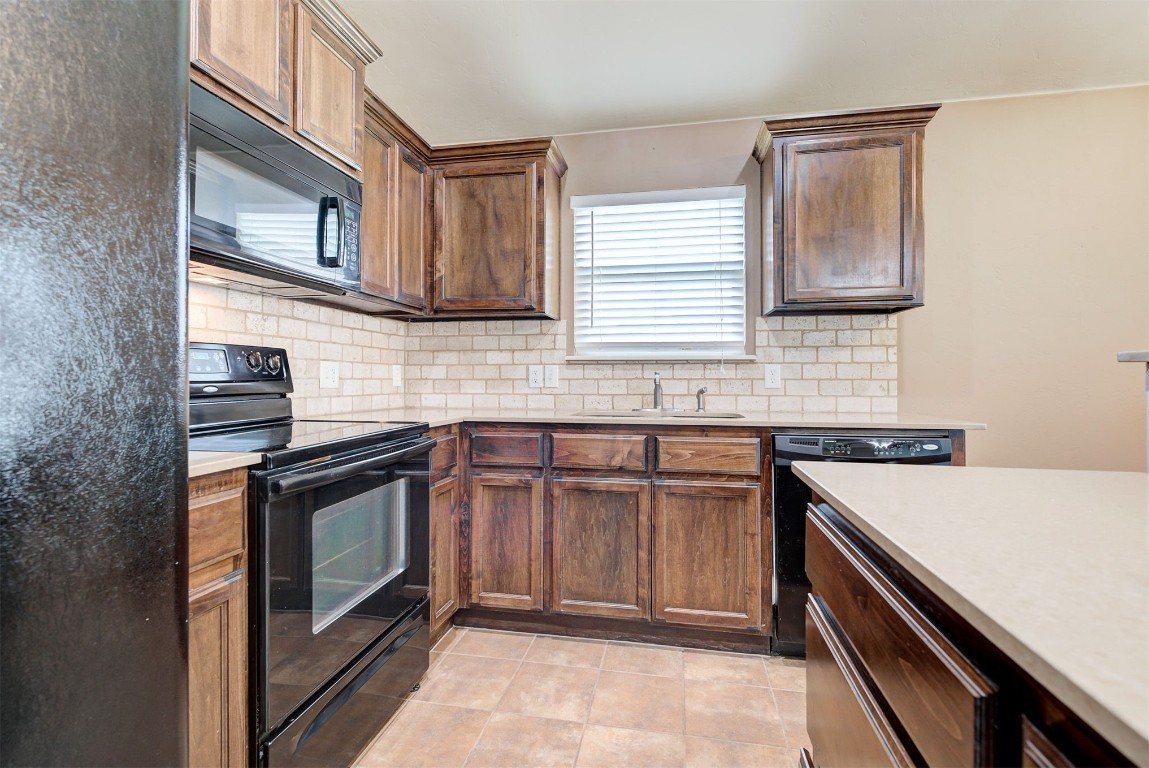 3508 Frederick Drive, Norman, OK 73071 kitchen featuring tasteful backsplash, sink, light tile floors, and black appliances