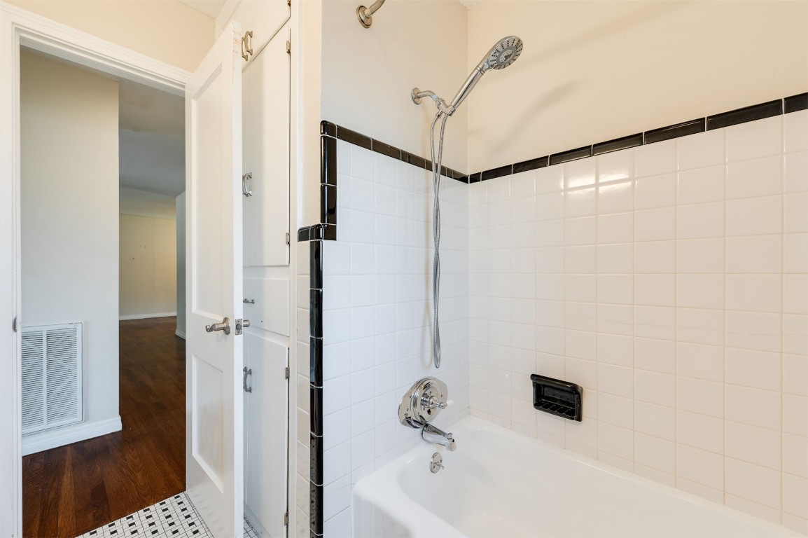 2707 NW 33 Street, Oklahoma City, OK 73112 bathroom with wood-type flooring and tiled shower / bath combo
