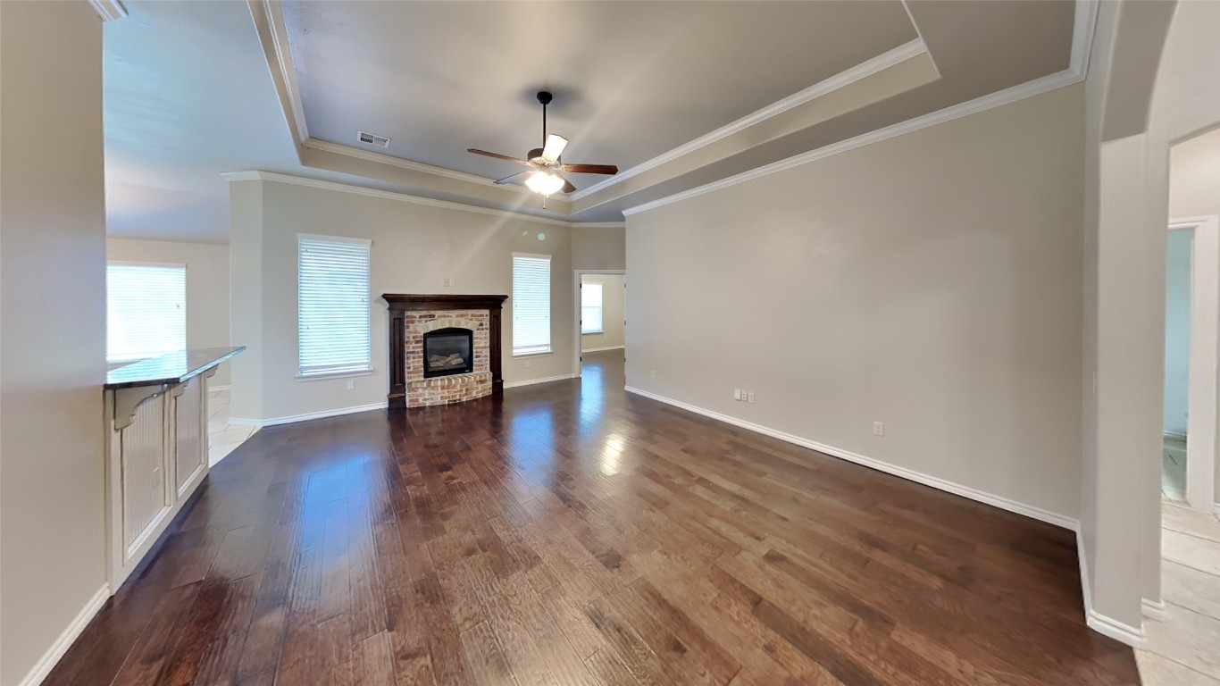725 Dusty Trail, Yukon, OK 73099 spare room featuring ornamental molding, carpet, ceiling fan, and a tray ceiling