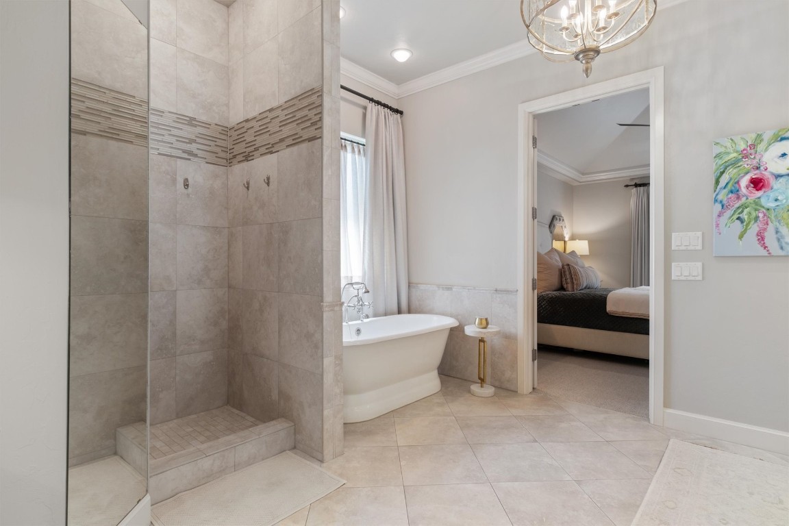 1200 Marlboro Lane, Nichols Hills, OK 73116 bathroom featuring plus walk in shower, tile floors, a chandelier, and ornamental molding