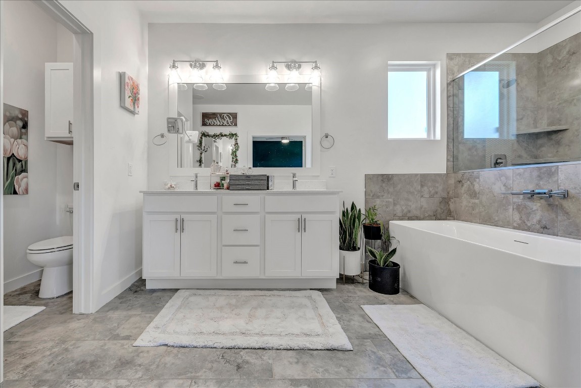 2140 Santa Monica Street, Edmond, OK 73034 bathroom with toilet, tile flooring, tile walls, and double sink vanity