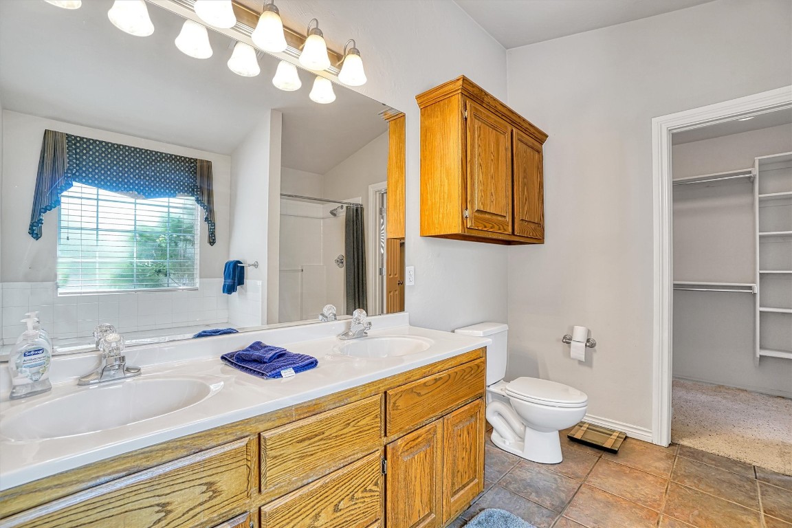 2910 Hunter Pointe, Altus, OK 73521 bathroom with double sink vanity, toilet, and tile flooring