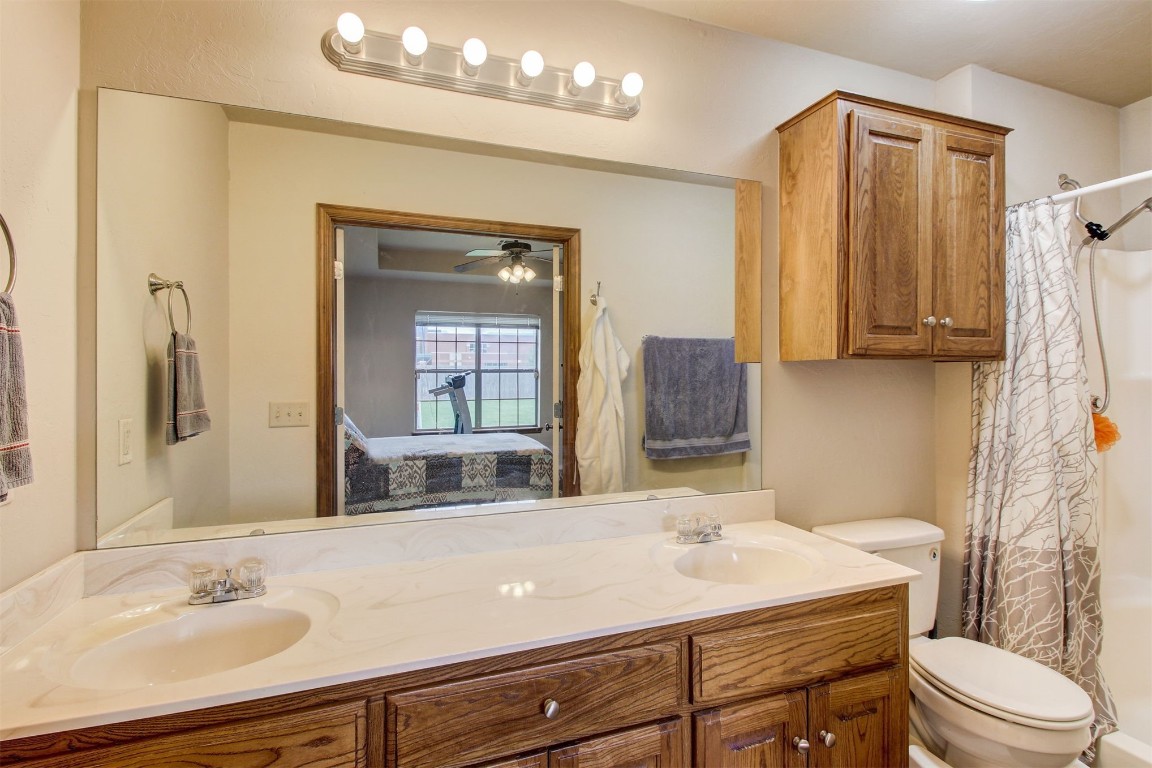 1306 SW 25th Street, Moore, OK 73170 bathroom featuring double vanity, ceiling fan, and toilet