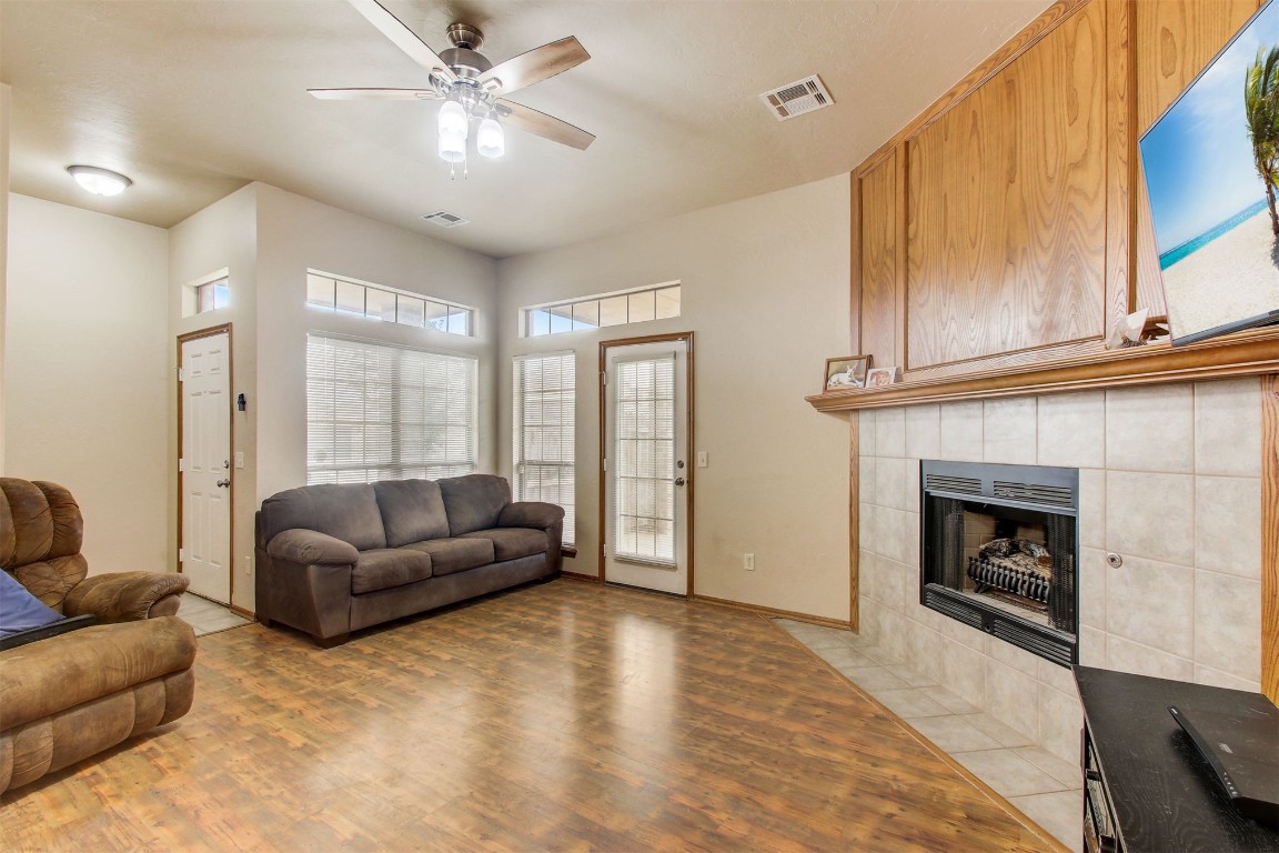 1306 SW 25th Street, Moore, OK 73170 living room featuring ceiling fan, a tile fireplace, and light wood-type flooring