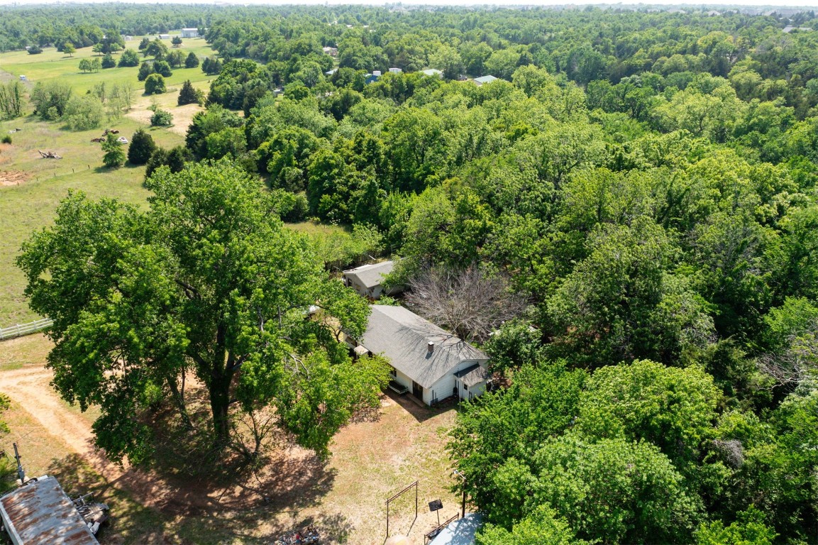 **This property is being sold with an adjoining 2.093 acres at 12125 S Coltrane Rd (MLS #1112252) for a total of $499,999**
Location, location, location! 16 MOL acres on paved road and situated between two areas of rapid development in Guthrie and Edmond. Enjoy a serene drive over a trickling creek and up a lush tree-lined driveway to a home tucked away in the trees. This property is laid out perfectly for a variety of activities and lifestyles. From the yard, a stunning path cuts through the woods and opens up to a thriving, open pasture, completely surrounded by tree-line for continued privacy. Plenty of space for grazing horses or taking the toys out for a spin. The second parcel included in this sale (MLS #1112252) sits on 2 MOL acres with 204' of Coltrane frontage and could easily be an option for a different or additonal new-build home site. The existing 2 bed/1 bath home on the 14 MOL acre parcel, while livable, is in need of some sprucing up. There is also an old storage barn, small metal shed in good shape, shop/garage, and mobile home on the property which would require some clean up. 10 minutes to coffee, dining, a brand new movie theatre and Crest Foods at Sooner & Covell, 10 minutes to the Golf Club of Edmond, and 15 minutes to the Lazy E. Quick and easy access to I-35 as well. Come renovate or tear down & build a beautiful home (or several!) with the kind of seclusion that keeps getting harder and harder to find!
