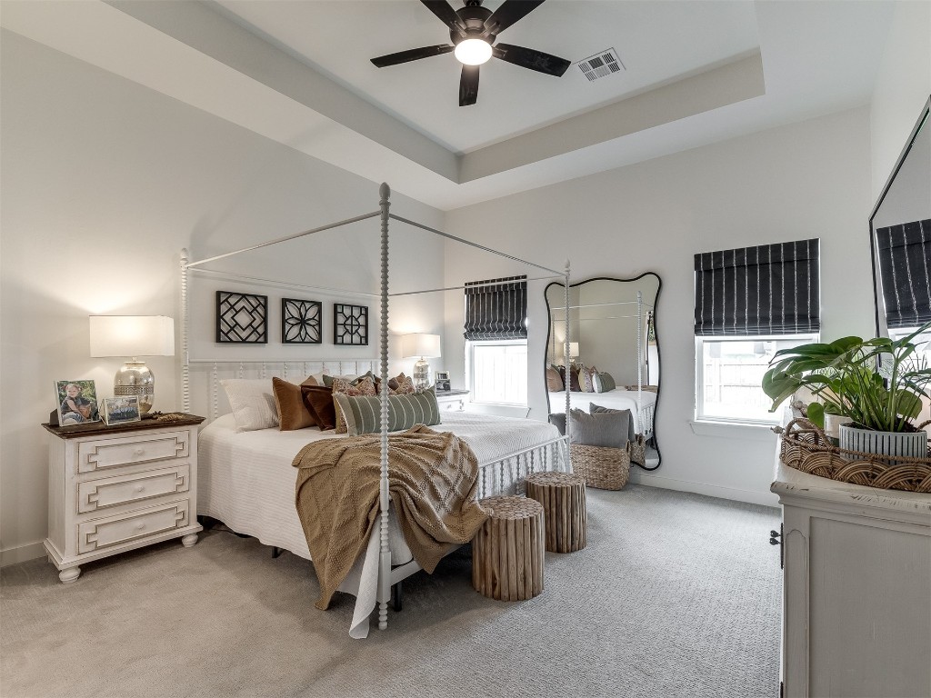 2300 El Cajon Street, Edmond, OK 73034 bedroom with a raised ceiling, ceiling fan, and light carpet