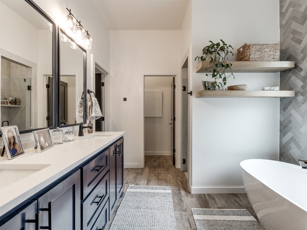 2300 El Cajon Street, Edmond, OK 73034 bathroom with hardwood / wood-style floors, a bath, large vanity, and double sink