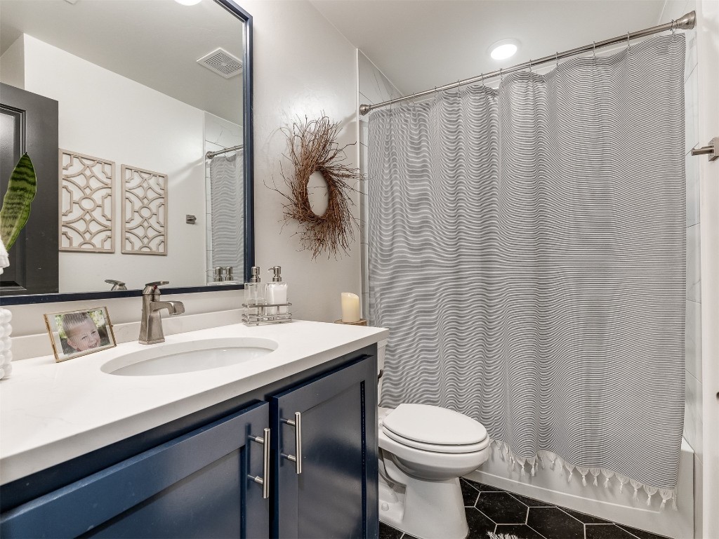 2300 El Cajon Street, Edmond, OK 73034 full bathroom with vanity, shower / bathtub combination with curtain, toilet, and tile flooring