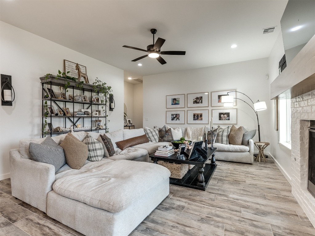 2300 El Cajon Street, Edmond, OK 73034 living room featuring light hardwood / wood-style flooring, ceiling fan, and a fireplace