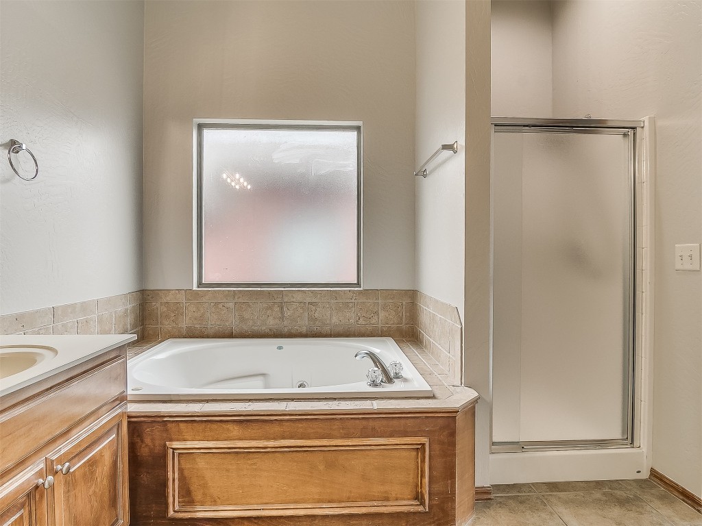 2613 SW 140th Street, Oklahoma City, OK 73170 bathroom featuring tile flooring, tiled bath, and double sink vanity