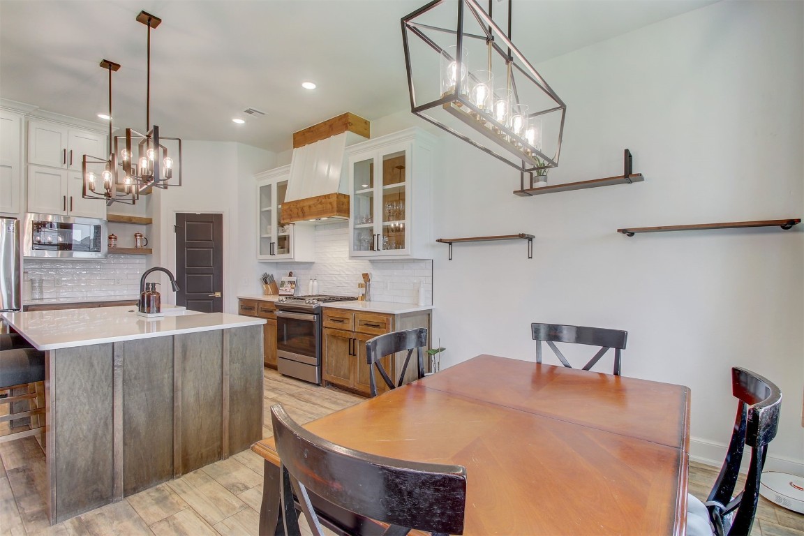 9224 NW 82nd Street, Yukon, OK 73099 dining space with light hardwood / wood-style flooring, sink, and a chandelier