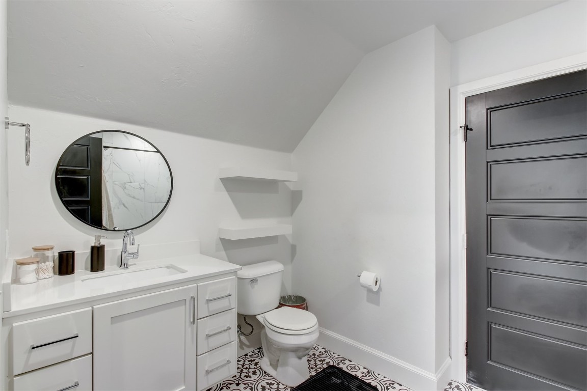 9224 NW 82nd Street, Yukon, OK 73099 bathroom featuring tile flooring, lofted ceiling, vanity, and toilet