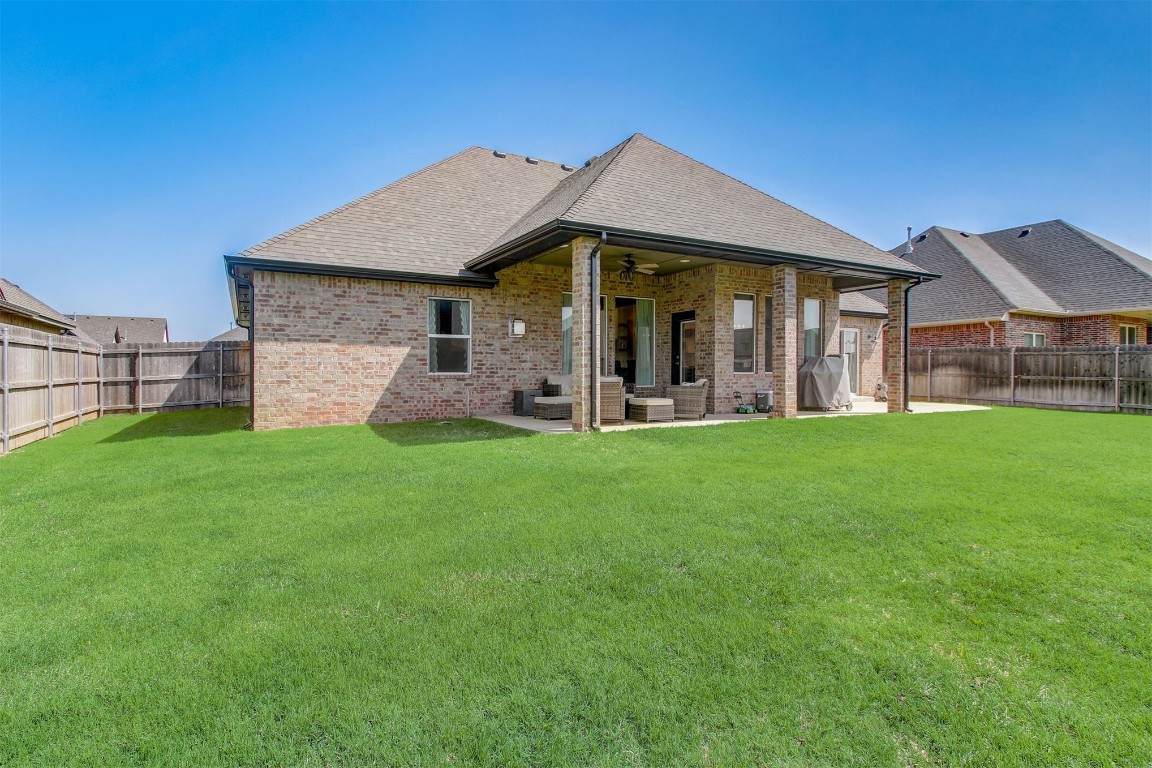 9224 NW 82nd Street, Yukon, OK 73099 back of house featuring a patio, a lawn, and ceiling fan