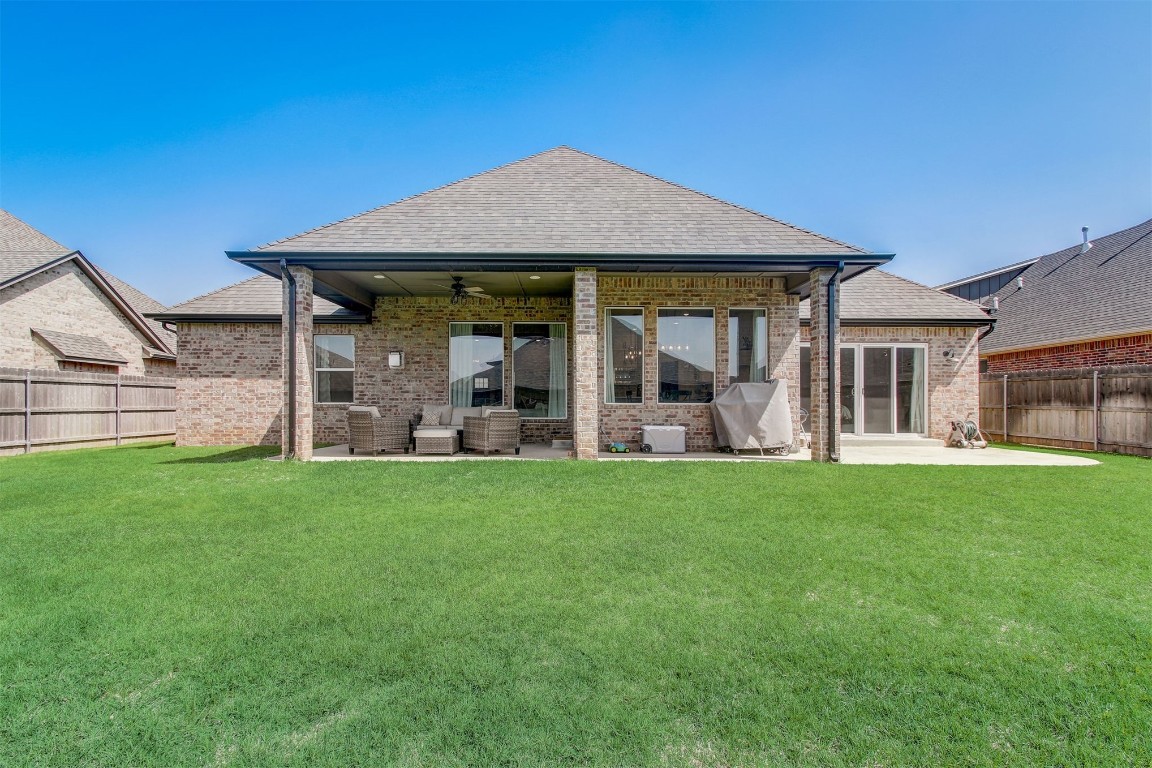 9224 NW 82nd Street, Yukon, OK 73099 back of house with a patio area, ceiling fan, and a lawn