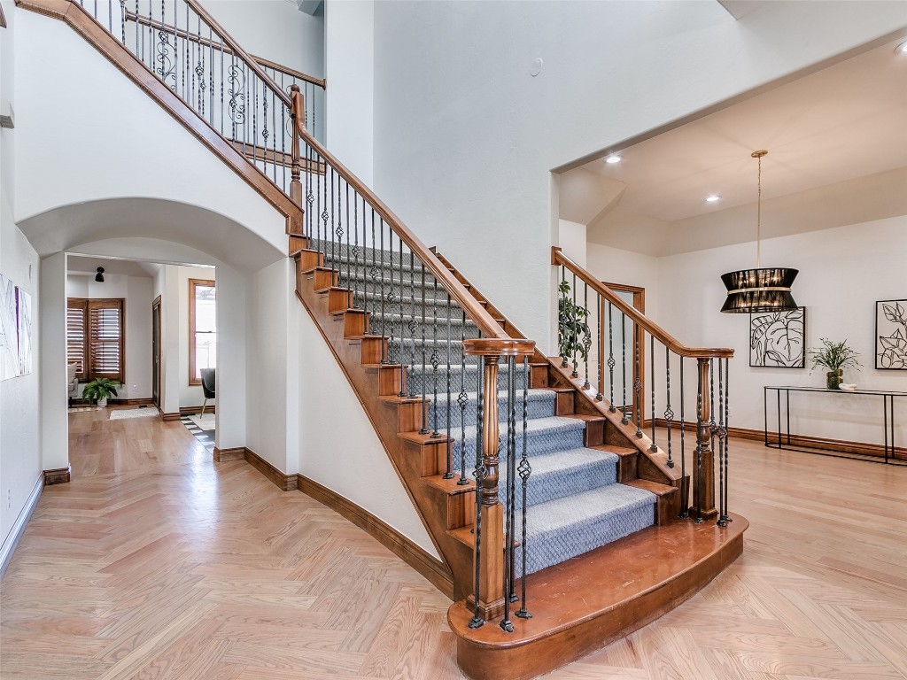 5201 NW 126th Court, Oklahoma City, OK 73142 stairs featuring light parquet flooring, a chandelier, and a high ceiling