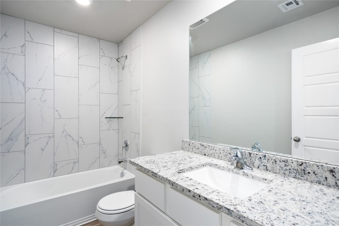 12713 Torretta Way, Yukon, OK 73099 full bathroom featuring oversized vanity, tiled shower / bath combo, and toilet