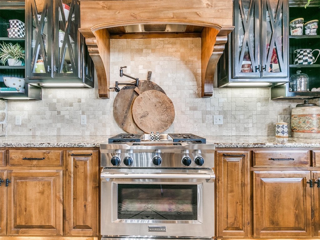 5400 N Piedmont Road, Piedmont, OK 73078 kitchen featuring tasteful backsplash, light stone countertops, and high end stainless steel range oven