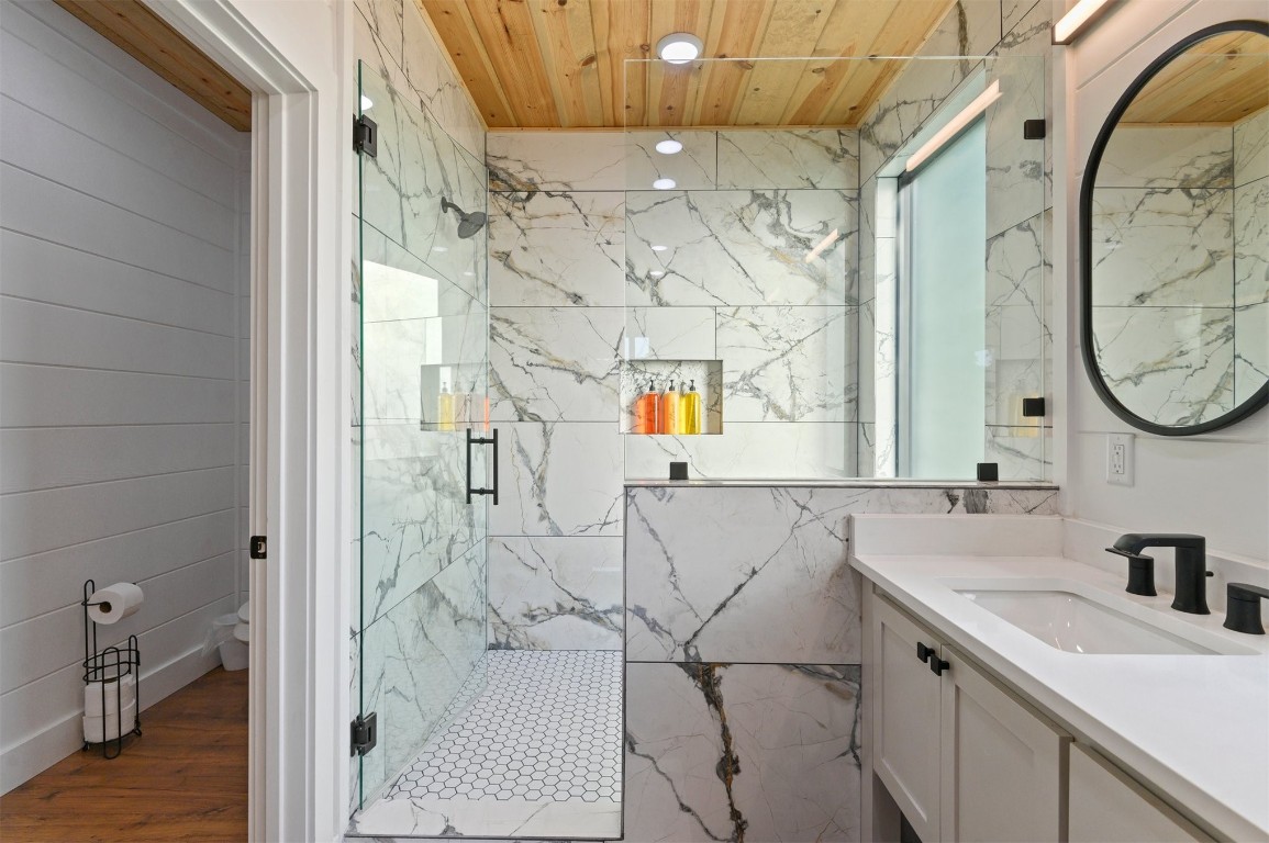 262 Forest Brook Loop, Broken Bow, OK 74728 bathroom featuring a shower with door, wood-type flooring, vanity, and wooden ceiling