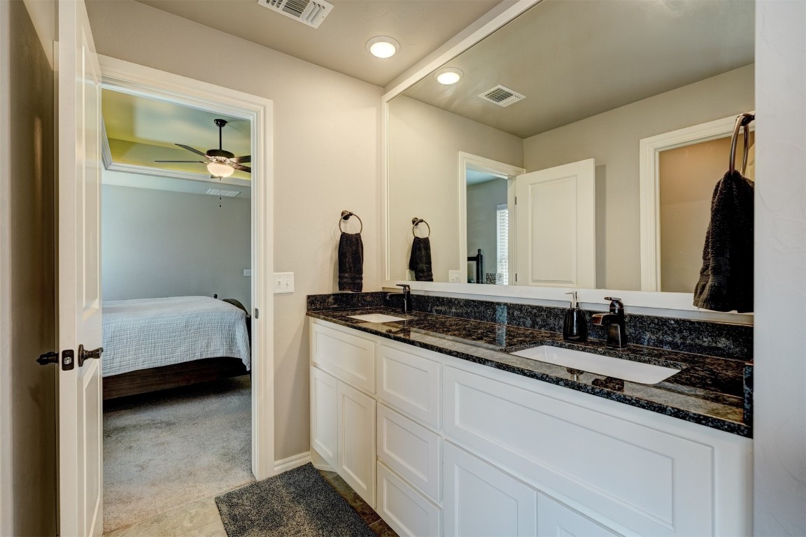 18700 Lazy Grove Drive, Edmond, OK 73012 bathroom with double vanity, tile floors, and ceiling fan