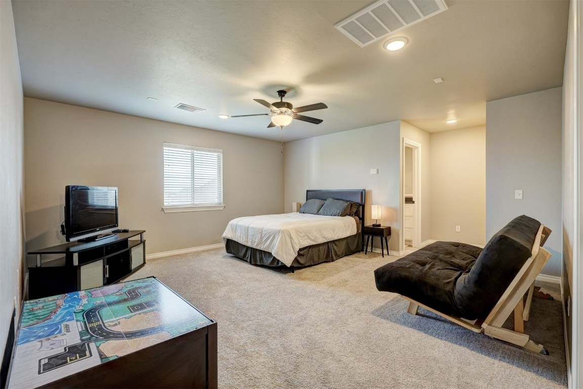 18700 Lazy Grove Drive, Edmond, OK 73012 carpeted bedroom with ceiling fan