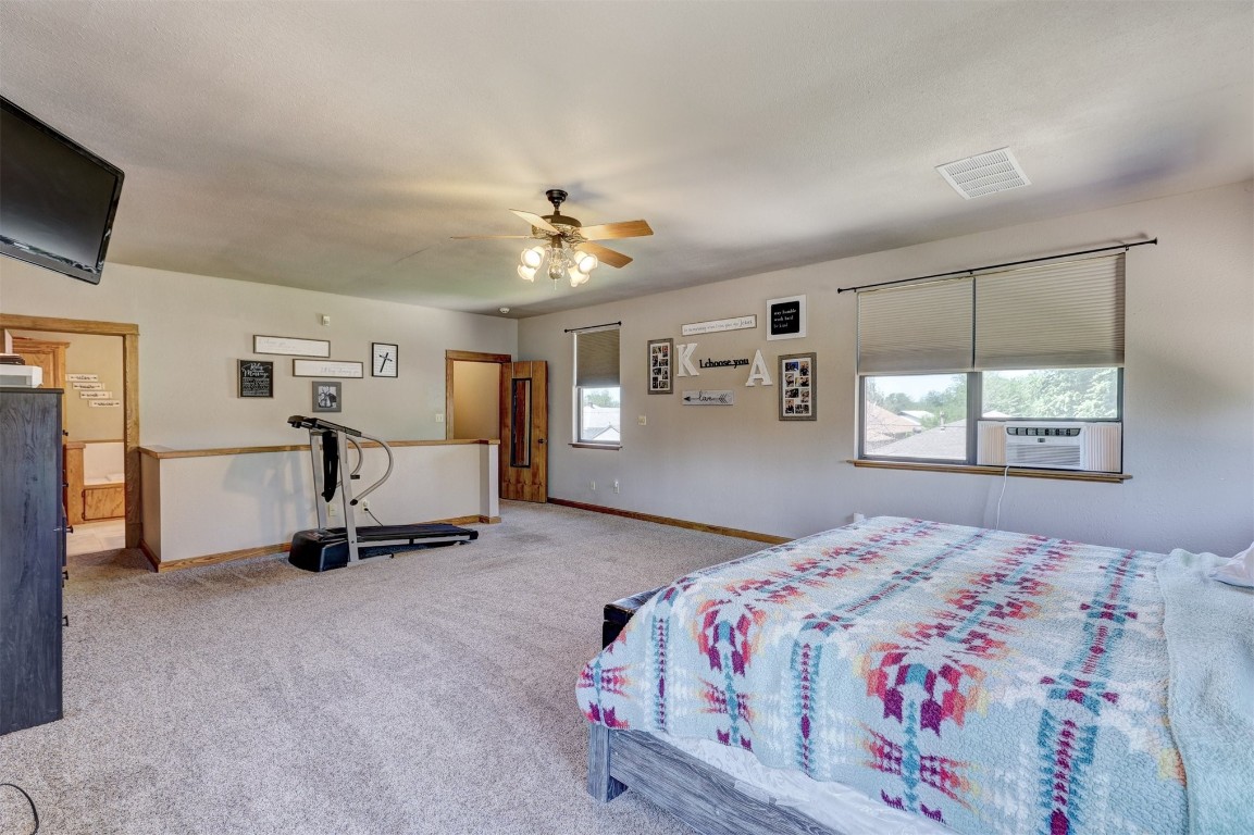 1008 Sunset Drive, El Reno, OK 73036 bedroom featuring ceiling fan, carpet flooring, and multiple windows