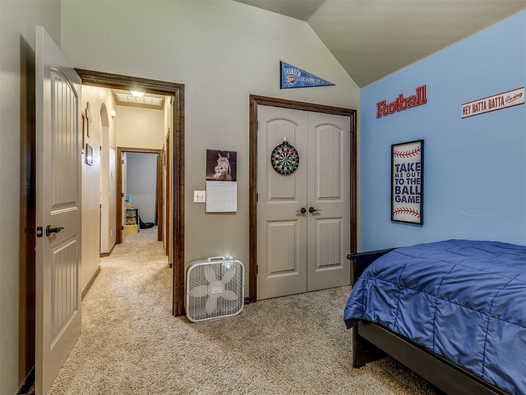 11816 SW 17th Street, Yukon, OK 73099 carpeted bedroom featuring a closet and vaulted ceiling