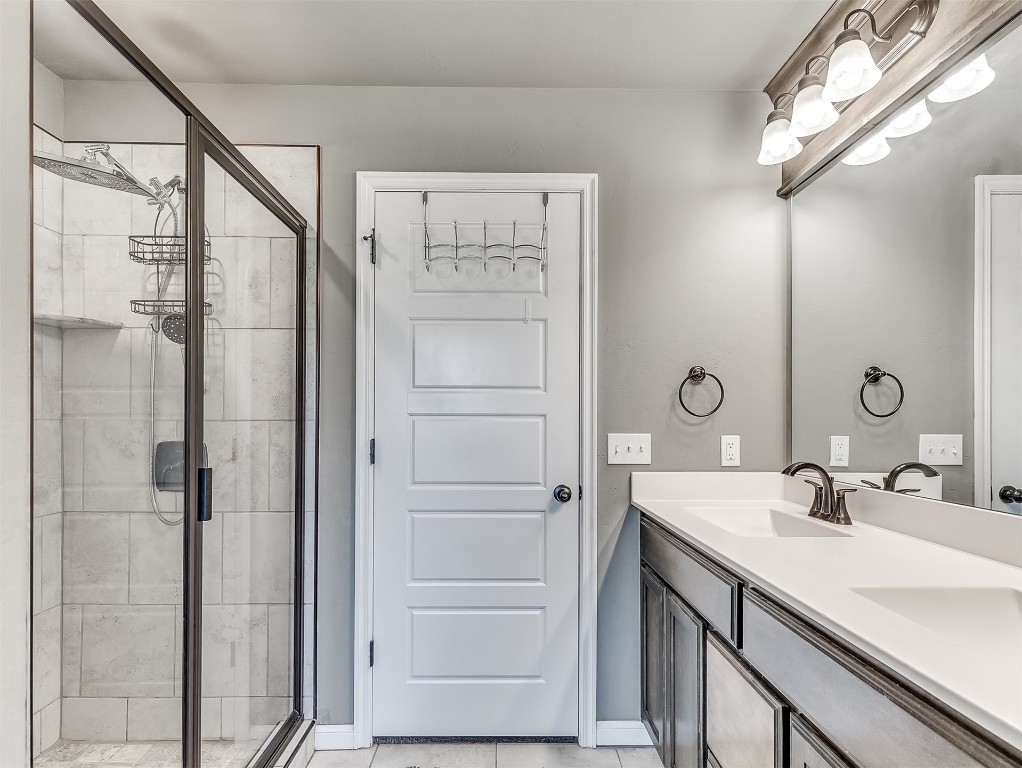 6716 NW 158th Street, Edmond, OK 73013 bathroom with walk in shower, tile flooring, and double sink vanity