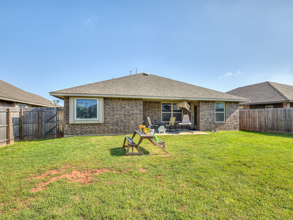 6716 NW 158th Street, Edmond, OK 73013 rear view of property featuring a patio and a yard