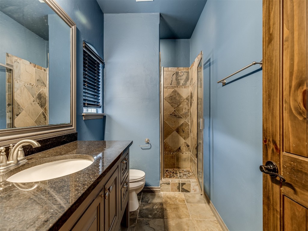 9612 SW 35th Street, Oklahoma City, OK 73179 bathroom featuring tiled shower, tile floors, toilet, and oversized vanity