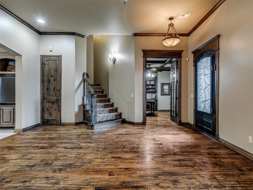 9612 SW 35th Street, Oklahoma City, OK 73179 entrance foyer featuring ornamental molding, ceiling fan, and dark wood-type flooring