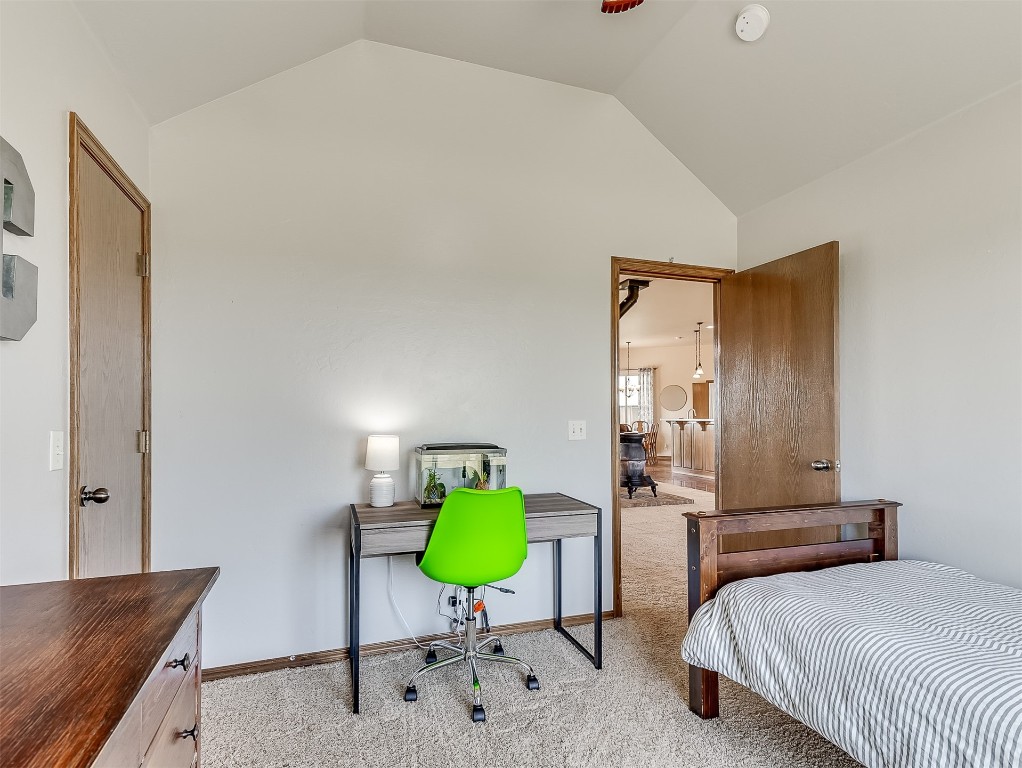3952 NE Arrowhead Road, Piedmont, OK 73078 carpeted bedroom featuring vaulted ceiling