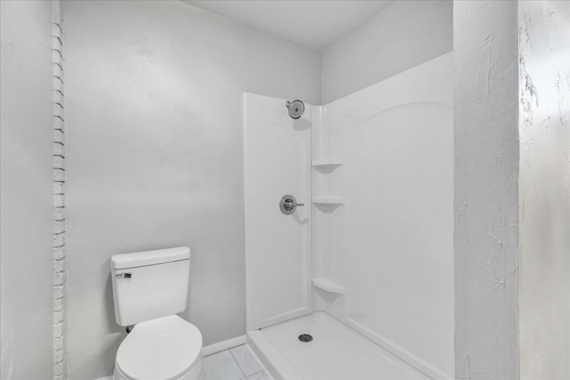 5712 N Roff Avenue, Oklahoma City, OK 73112 bathroom featuring walk in shower, toilet, and tile floors
