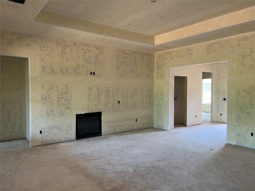 10305 Two Lakes Drive, Yukon, OK 73099 unfurnished living room featuring concrete flooring and a raised ceiling
