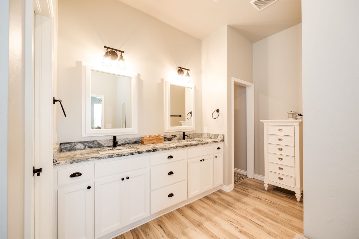 2321 NW 187th Terrace, Edmond, OK 73012 bathroom with hardwood / wood-style floors, oversized vanity, and double sink
