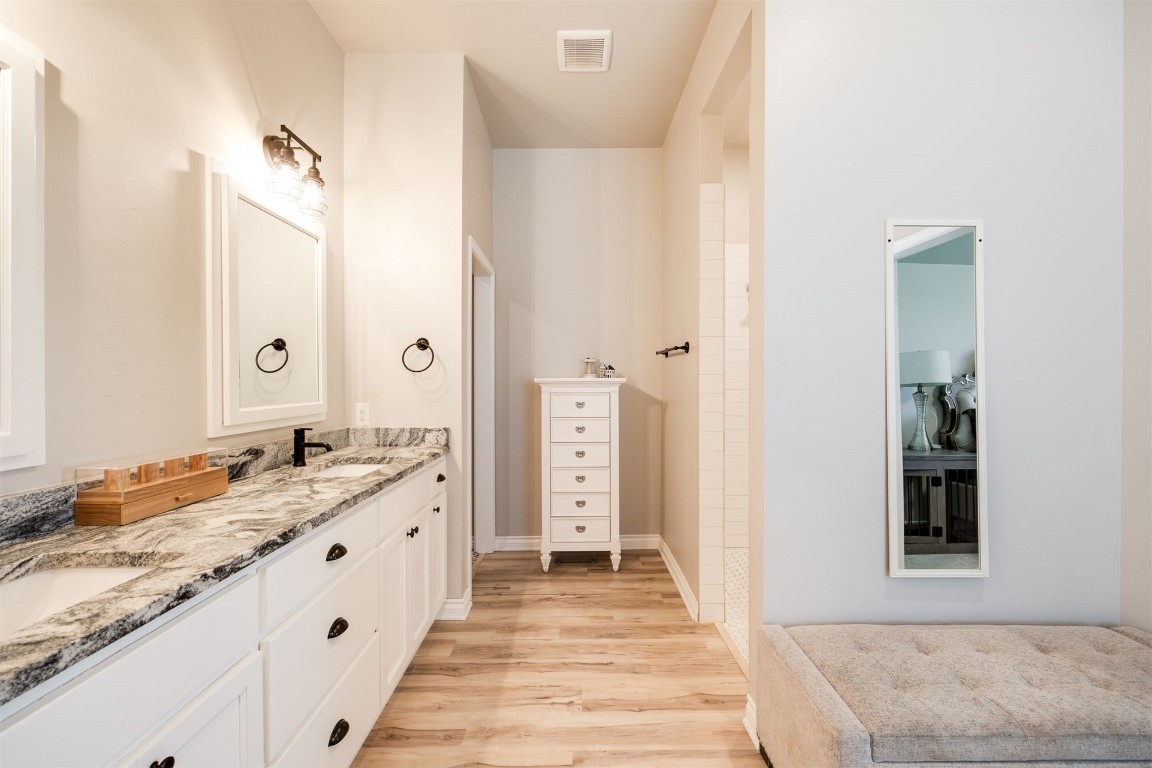 2321 NW 187th Terrace, Edmond, OK 73012 bathroom featuring dual bowl vanity and hardwood / wood-style flooring
